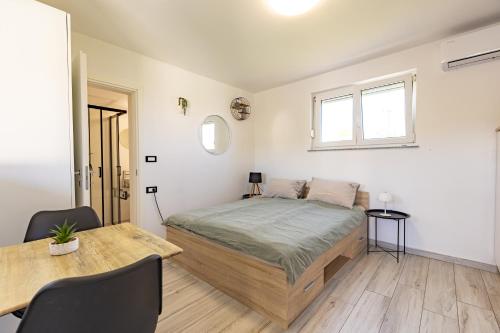 a bedroom with a large bed and a table at LaraBella Salt fields view studio in Portorož