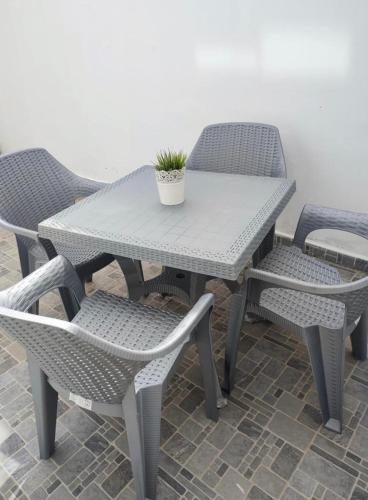 a white table and chairs with a potted plant on it at Appartement Nature & Plage in Menzel Jemil