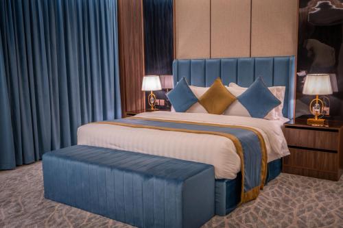 a bedroom with a large bed with a blue headboard at بروليت للشقق الفندقية in Khamis Mushayt