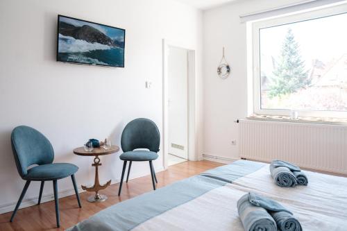 a bedroom with two chairs and a bed and a window at Sunny Maritime Apartment near Hannover central station in Hannover