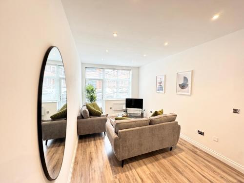 a living room with two couches and a mirror at STUNNING APARTMENT - 2 DOUBLE BEDROOMS - EN-SUITE - FREE ALLOCATED PARKING - JQ QUARTER - BIRMINGHAM CITY CENTRE - SLEEPS 6 GUESTS - 2 BATHROOMs in Birmingham