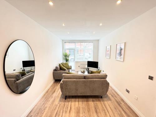 a living room with two couches and a mirror at STUNNING APARTMENT - 2 DOUBLE BEDROOMS - EN-SUITE - FREE ALLOCATED PARKING - JQ QUARTER - BIRMINGHAM CITY CENTRE - SLEEPS 6 GUESTS - 2 BATHROOMs in Birmingham