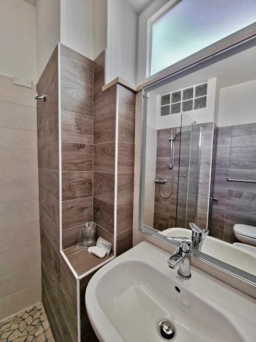 a bathroom with a sink and a toilet and a mirror at Hotel Rossella in Rimini