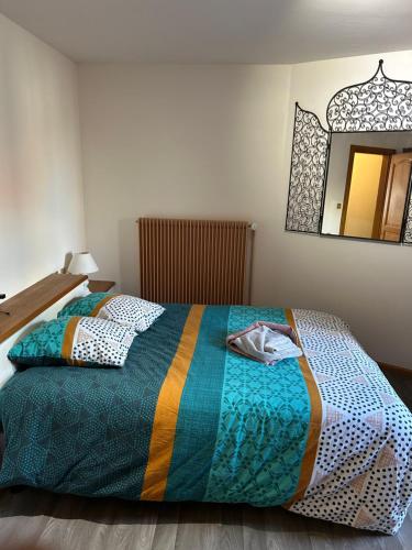 - un lit avec une couverture colorée et un miroir dans l'établissement Ammerschwihr vignoble Alsace, à Ammerschwihr