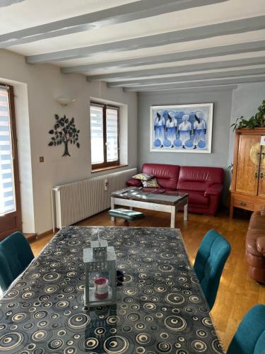 un salon avec une table et un canapé rouge dans l'établissement Ammerschwihr vignoble Alsace, à Ammerschwihr