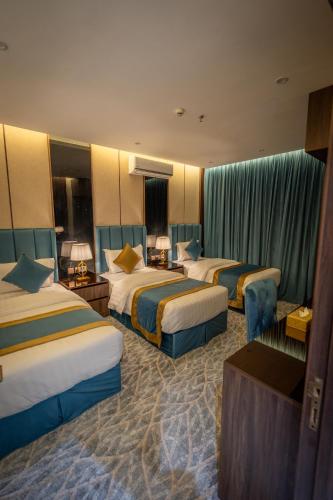 a hotel room with three beds in a room at بروليت للشقق الفندقية in Khamis Mushayt