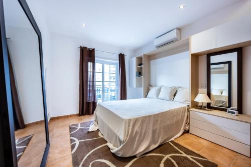 ein Schlafzimmer mit einem Bett und einem großen Spiegel in der Unterkunft South East Wind Apartment in Lagos