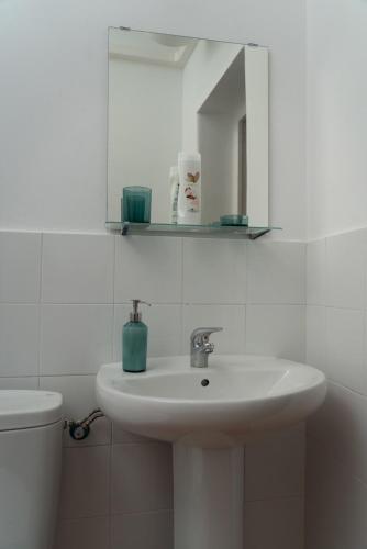 a bathroom with a sink and a mirror and a toilet at Apartamento centro 1A in Huelva