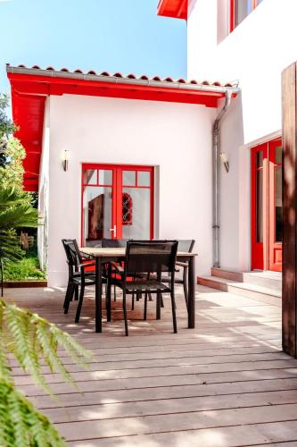 une table et des chaises en bois sur une terrasse dans l'établissement Villa de charme à 2 pas de la plage, à La Teste-de-Buch