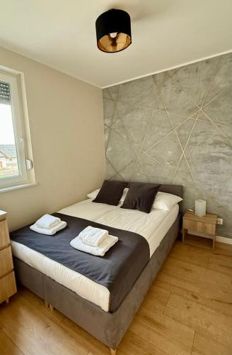 a bedroom with a bed with two towels on it at Ogrodowa70 Apartment in Sztutowo