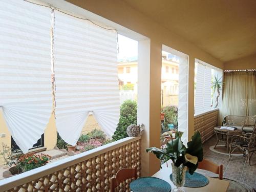 a large window with white blinds on a balcony at Semi-detached house, La Casa di Marinico in Alghero