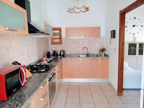 a kitchen with a sink and a clock on the wall at Semi-detached house, La Casa di Marinico in Alghero
