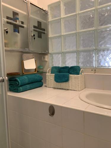 - une salle de bains avec des serviettes sur un comptoir à côté d'un lavabo dans l'établissement Maison de ville Centre de Narbonne 3 moulins, à Narbonne