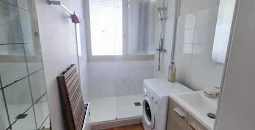 une salle de bain avec une machine à laver et un lavabo dans l'établissement Appart 8 pers, 80M2, parking privée, Mer & lac à pied, Face parc aquatique, à La Grande Motte
