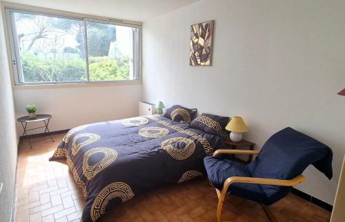 une chambre avec un lit, une chaise et une fenêtre dans l'établissement Appart 8 pers, 80M2, parking privée, Mer & lac à pied, Face parc aquatique, à La Grande Motte