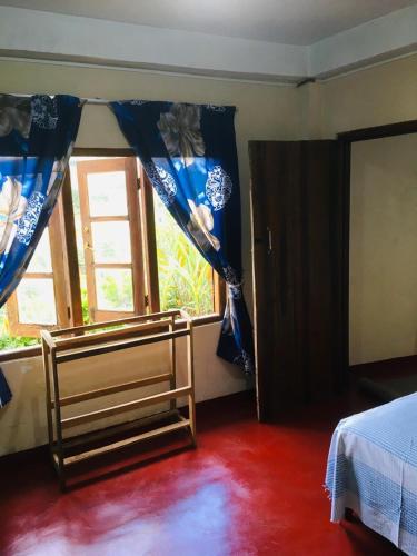 ein Schlafzimmer mit einem Bett und einem Fenster in der Unterkunft Sams Cottage in Nuwara Eliya