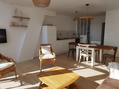 un salon avec une table et des chaises et une cuisine dans l'établissement Face mer Direct plage, à La Turballe
