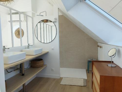 une salle de bain avec un lavabo et un miroir dans l'établissement Face mer Direct plage, à La Turballe