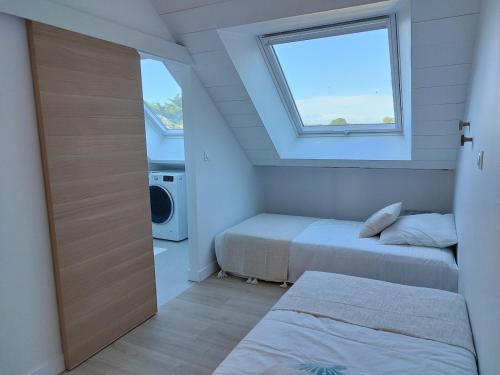 une petite chambre avec deux lits et une fenêtre dans l'établissement Face mer Direct plage, à La Turballe