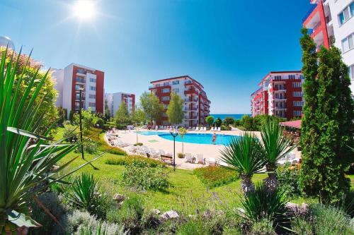 Una piscina al aire libre en una ciudad con edificios altos. en Orchid Fort Noks Design, en Sunny Beach