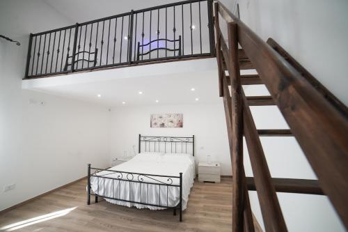 a bedroom with a bed and a staircase at Corte Maria in Castri di Lecce