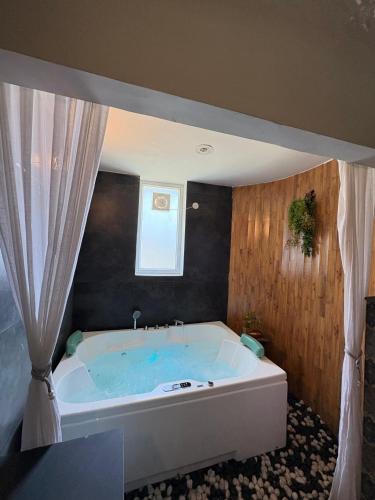 a large bath tub in a bathroom with a window at Aristaa Morni Hills: Pristine Stay in the Wild in Morni