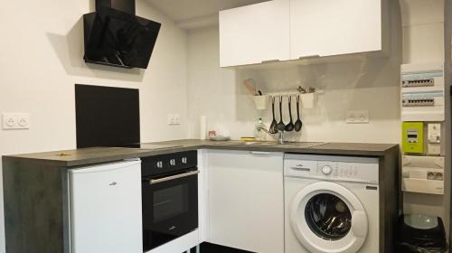 une cuisine avec un lave-linge et un lave-linge dans l'établissement Grand studio neuf au calme, à Reims