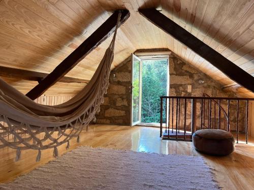 a room with a hammock in a attic at Casa da Mena - Casa de Campo no Caramulo in Vouzela