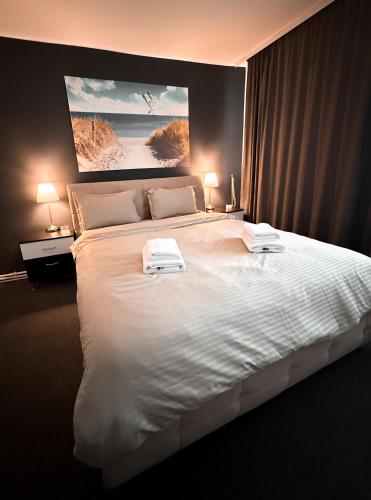 a bedroom with a large white bed with two towels on it at Hideout Cozy 2 rooms near Palas Mall & city center, warmy, invoice available, parking space, Ultracomfy in Iaşi