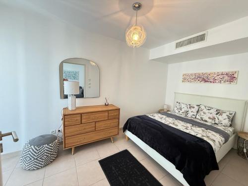 a bedroom with a bed and a dresser and a mirror at Appartement Nice Carré d Or in Nice