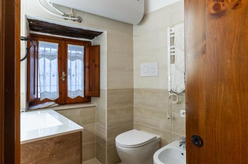 a bathroom with a toilet and a sink and a mirror at La Casa nella pietra suite Gargano in Vico del Gargano