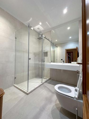 a bathroom with a shower and a toilet and a sink at Seaside Duplex Stone Villa in Qeparo