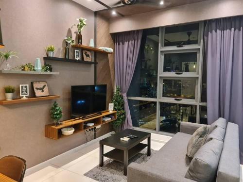 a living room with a couch and a tv at The Roberstson family suite with city views in Kuala Lumpur