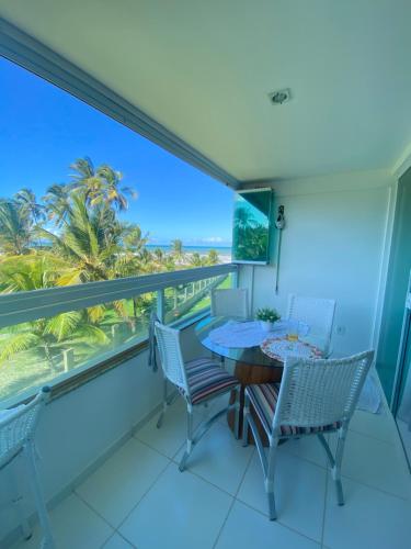 un balcon avec une table et des chaises et une vue sur l'océan dans l'établissement Pé na Areia e Vista ao Mar em Águas de Olivença Privê, à Olivença