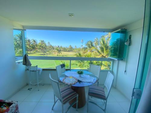 une salle à manger avec une table et des chaises et une grande fenêtre dans l'établissement Pé na Areia e Vista ao Mar em Águas de Olivença Privê, à Olivença