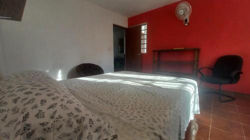 a bedroom with a bed and a red wall at Casa 3 flamencos - estudio y apartamento in Celestún