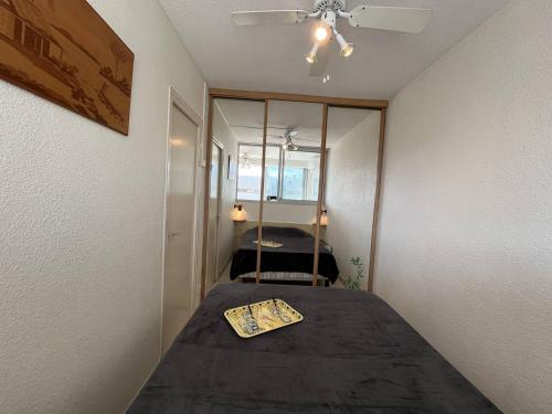 Cette chambre comprend un lit avec un miroir et une table. dans l'établissement Apt studio 2 couchages CAP D'AGDE NATURISME CN060-D28, au Cap d'Agde