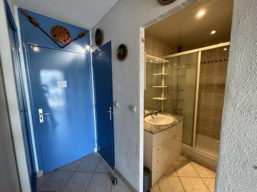 La salle de bains est pourvue d'une douche bleue et d'un lavabo. dans l'établissement Apt studio 2 couchages CAP D'AGDE NATURISME CN060-D28, au Cap d'Agde