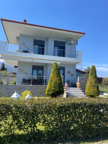 a white house with trees in front of it at Plaka Luxury Villa in Litochoro
