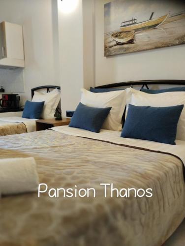 two beds with blue and white pillows in a room at Thanos ,Rooms and Apartments in Ouranoupoli