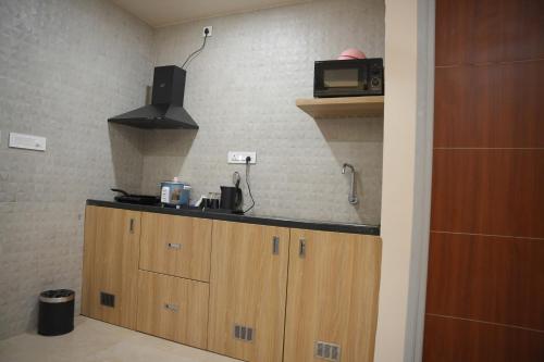 a kitchen with a counter top with a microwave at KVP GOLDEN INN in Tirupati