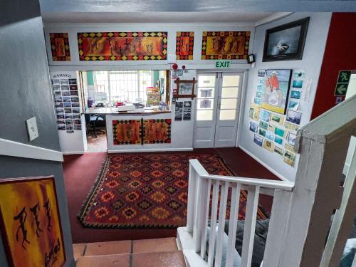 a room with a staircase and a room with a table at Hermanus Backpackers & Budget Accommodation in Hermanus