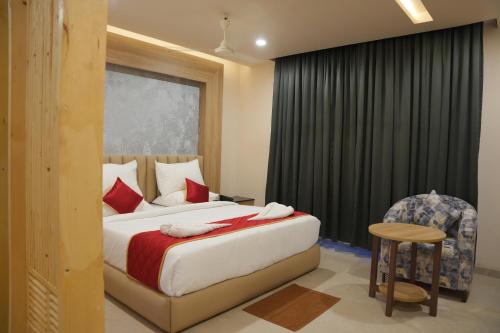 a hotel room with a bed and a chair at KVP GOLDEN INN in Tirupati