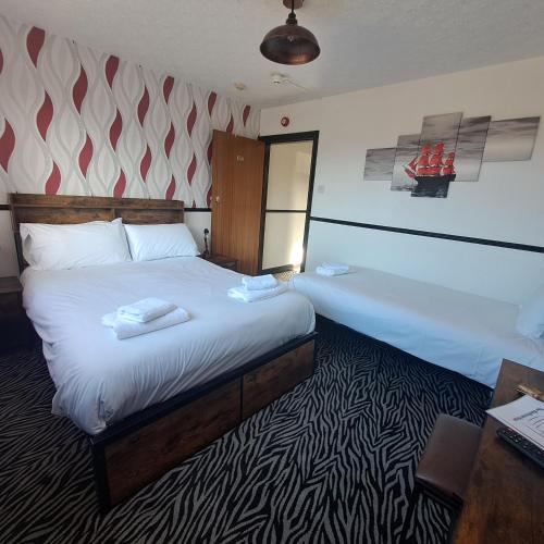 a hotel room with a large bed and a desk at Boathouse Hotel in Holyhead