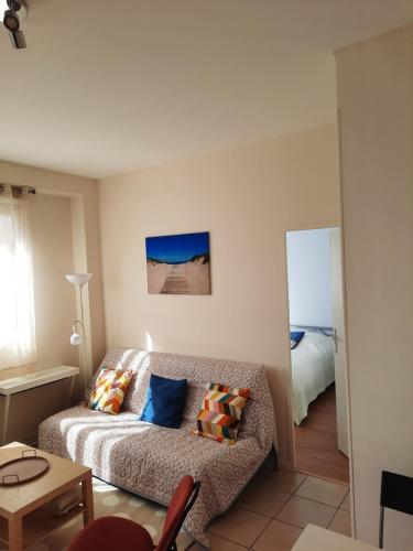 un salon avec un canapé et un lit dans l'établissement Les Mouettes, au Havre