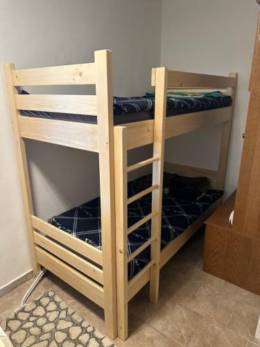 a wooden bunk bed with blue sheets on it at Apartments Barbra - Robinson life in Slovenj Gradec
