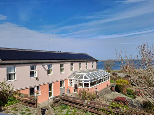 a building with a solarium next to a body of water at Boathouse Hotel in Holyhead
