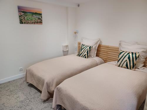 deux lits côte à côte dans une pièce dans l'établissement Plain-pied 80 m2 dans maison, parking privé gratuit, gare directe Paris, à Versailles