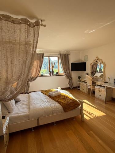 a bedroom with a bed and a large window at Barnfields Retreat in Little Clacton