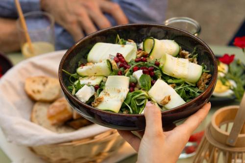a person holding up a bowl of salad at Campanile Strasbourg - Illkirch Geispolsheim in Geispolsheim